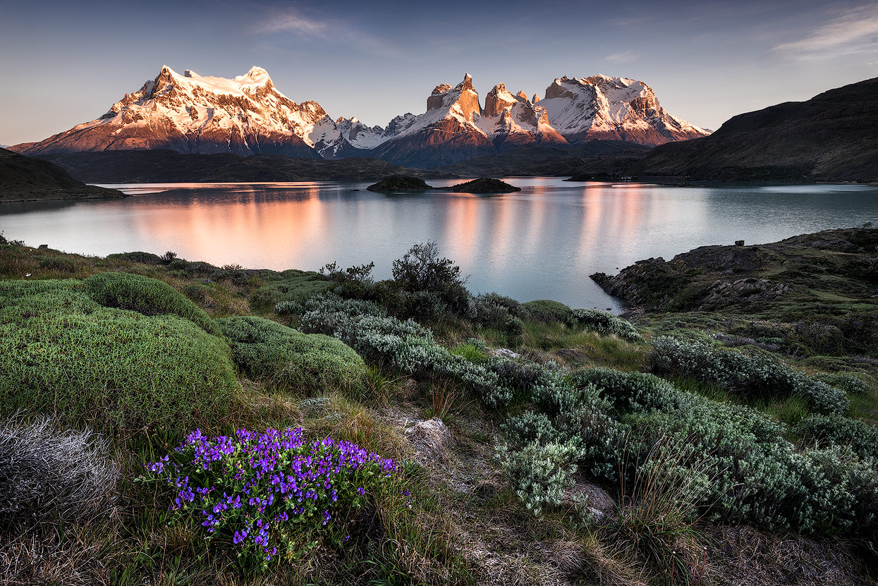 Montanhas e lago na Patagônia, iluminados pela luz do sol.