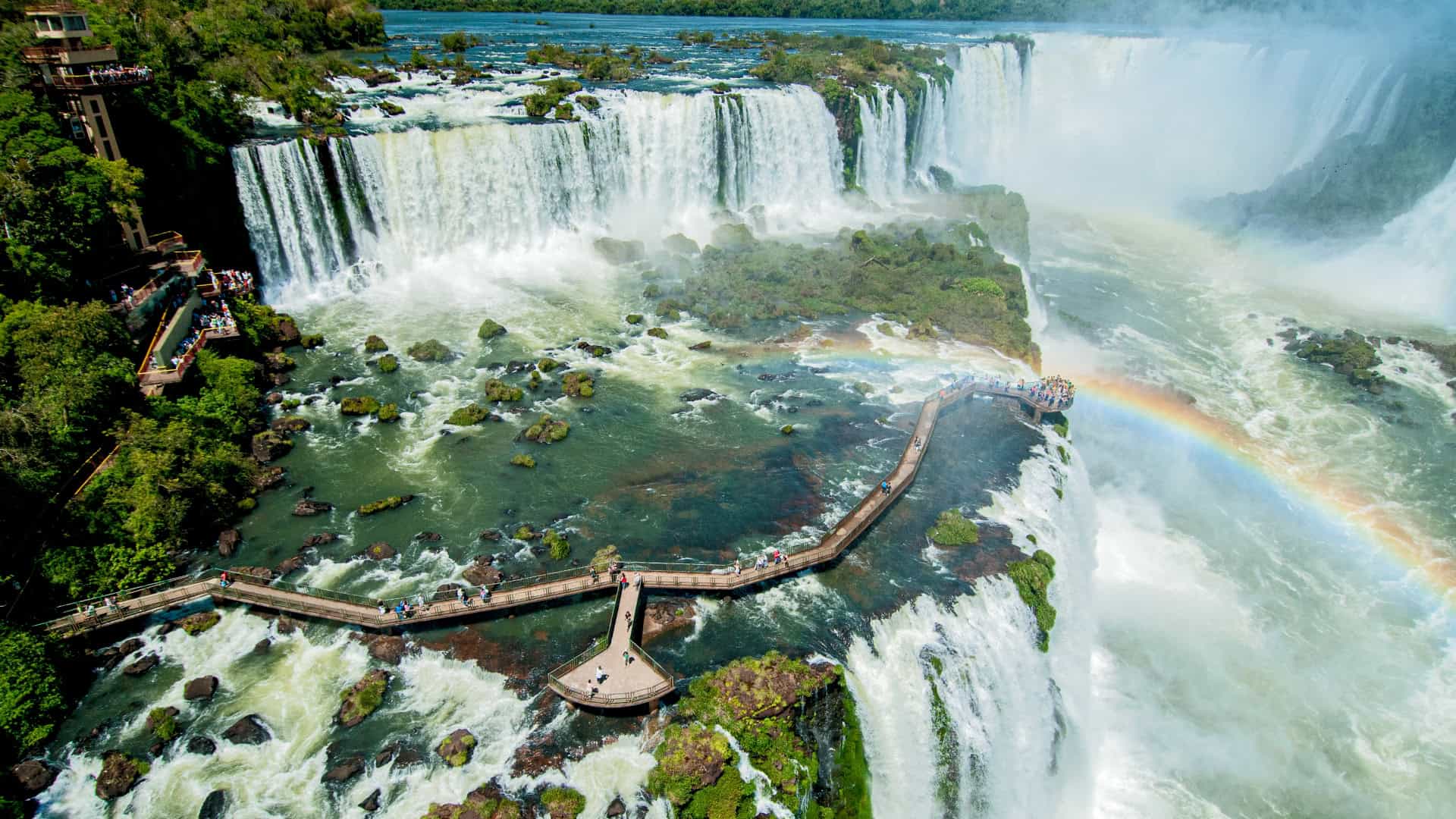 Quedas d’água, passarelas e arco-íris nas Cataratas do Iguaçu.